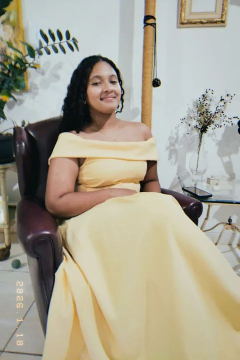 Cliente com vestido amarelo longo ombro a ombro